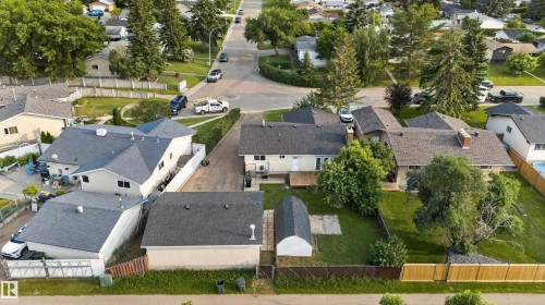 Expansive property featuring a detached garage, a secondary outbuilding, a wooden privacy fence, a paved driveway, and mature landscaping - 33 Brookside Avenue, Spruce Grove, AB 