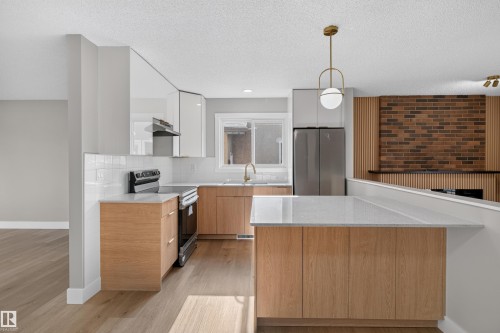 Kitchen featuring light wood-finish lower cabinetry, white upper cabinetry, and a white subway tile backsplash - 33 Brookside Avenue, Spruce Grove, AB 
