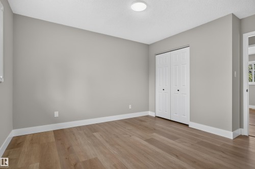 Room featuring wood-finish flooring, light gray wall paint, and white baseboards - 33 Brookside Avenue, Spruce Grove, AB 
