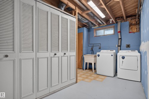 Laundry area featuring a washer, dryer, utility sink, and overhead fluorescent lighting - 33 Brookside Avenue, Spruce Grove, AB 