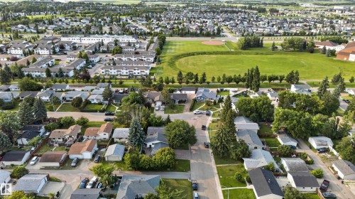 Aerial perspective showcasing a residential neighborhood with a central green space - 33 Brookside Avenue, Spruce Grove, AB 