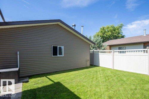 Manicured lawn area featuring a white privacy fence with lattice accents - 10420 111 Avenue, Westlock, AB 