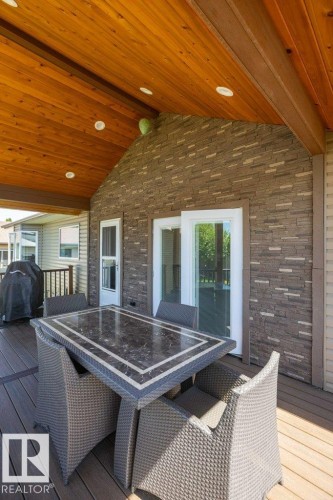 Covered outdoor living space featuring a wood-finish vaulted ceiling with recessed lighting - 10420 111 Avenue, Westlock, AB 