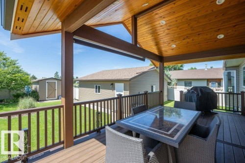 Covered deck featuring a wood-finish ceiling with recessed lighting - 10420 111 Avenue, Westlock, AB 