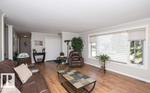Living area featuring wood-finish flooring and crown molding - 10420 111 Avenue, Westlock, AB 