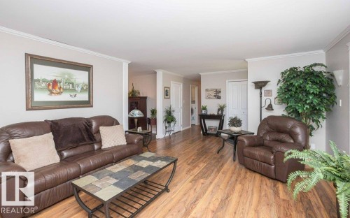 Hardwood-finish flooring throughout, featuring crown molding, neutral wall tones, and recessed doorways - 10420 111 Avenue, Westlock, AB 