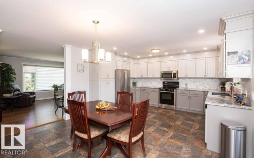 Open-concept kitchen and dining area featuring stone-look tile flooring - 10420 111 Avenue, Westlock, AB 