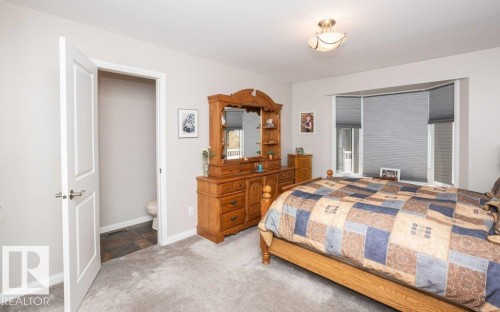 Carpeted room with light grey walls and a semi-flush ceiling light fixture - 10420 111 Avenue, Westlock, AB 