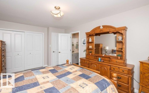 Room featuring neutral wall paint, carpet flooring, a ceiling-mounted light fixture, and white bi-fold closet doors - 10420 111 Avenue, Westlock, AB 