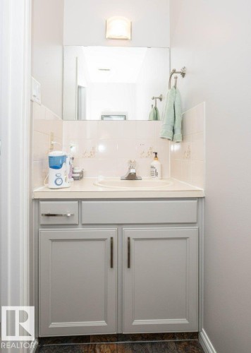 Bathroom vanity featuring light gray cabinetry, a built-in sink, and a light-toned countertop - 10420 111 Avenue, Westlock, AB 