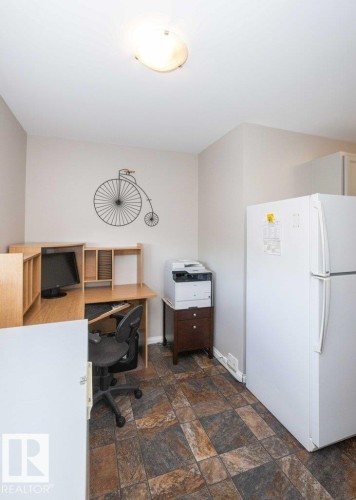 Stone-look tile flooring complementing light-toned walls and a flush-mount ceiling light - 10420 111 Avenue, Westlock, AB 
