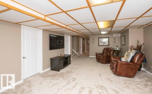 Carpeted room with neutral wall tones and a drop ceiling with integrated lighting - 10420 111 Avenue, Westlock, AB 