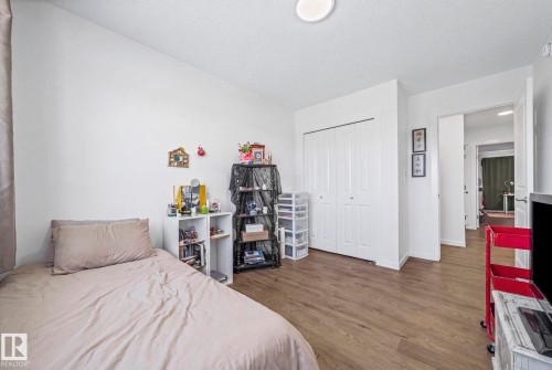 Room featuring wood-finish flooring, white walls, and a white bi-fold closet - 16 19904 31 Avenue, Edmonton, AB 