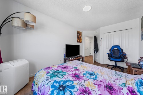 Recessed ceiling lighting illuminates the space featuring wood-finish flooring and white bi-fold closet doors - 16 19904 31 Avenue, Edmonton, AB 