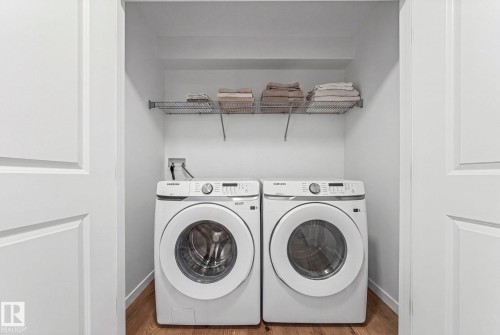 Dedicated laundry area featuring a white front-loading washer and dryer set - 16 19904 31 Avenue, Edmonton, AB 