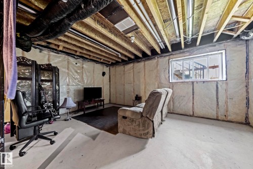 Unfinished basement space featuring exposed ceiling joists, overhead ductwork, and insulation-lined walls - 16 19904 31 Avenue, Edmonton, AB 