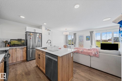 Open-concept living space with wood-finish flooring throughout - 16 19904 31 Avenue, Edmonton, AB 