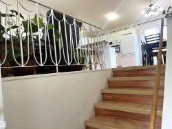 Staircase featuring wood-finish risers and stone-look treads, with a wood handrail - 