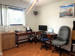 Interior room featuring wood-finish flooring, a window with horizontal blinds, and neutral wall tones - 