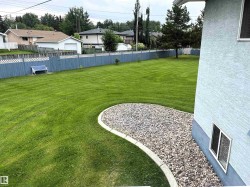 Expansive lawn area featuring a decorative gravel bed with a concrete border - 