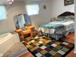 Spacious interior featuring wood-finish flooring, white walls, and bright windows - 