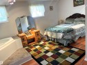 Spacious interior featuring wood-finish flooring, white walls, and bright windows - 4914 51 Ave, Entwistle, AB 