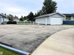 Detached garage with white overhead door and stucco exterior - 
