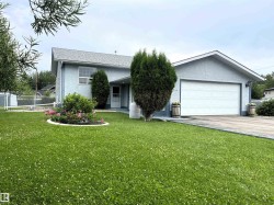Light blue stucco exterior with a prominent attached two-car garage - 
