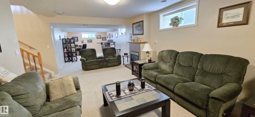 Finished lower level featuring a fireplace, carpeted flooring, and a recessed window - 4221 46 Street, Vegreville, AB 
