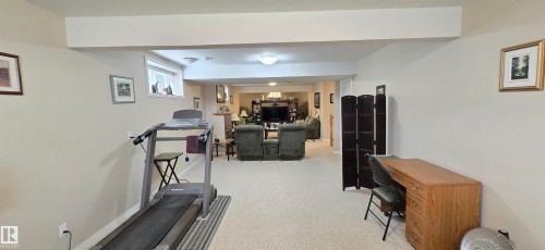 Finished lower level featuring neutral carpeting throughout, recessed lighting, and a window providing natural illumination - 4221 46 Street, Vegreville, AB 