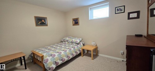 Carpeted room featuring light beige walls and a single window with blinds - 4221 46 Street, Vegreville, AB 