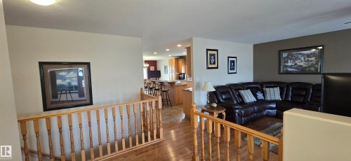 Hardwood flooring throughout, with a wood spindle railing and painted walls - 4221 46 Street, Vegreville, AB 