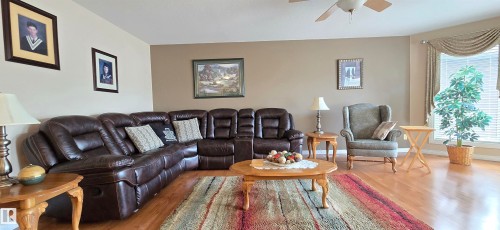 Spacious living area featuring wood-finish flooring, a neutral color palette, and a bay window - 4221 46 Street, Vegreville, AB 