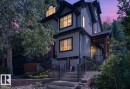 Multi-level property exterior featuring light-colored horizontal siding, dark trim, and a prominent brick foundation - 20 4821 Terwillegar Common, Edmonton, AB 