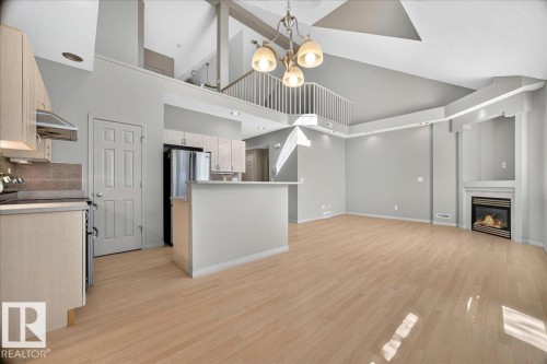 Open-concept main living area with high vaulted ceilings and light wood-finish flooring - 20 4821 Terwillegar Common, Edmonton, AB 
