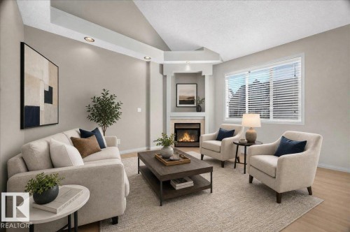 Living area featuring an electric fireplace with a stone surround, integrated shelving, and recessed lighting - 20 4821 Terwillegar Common, Edmonton, AB 