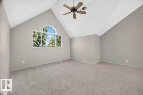Spacious room featuring a vaulted ceiling and a large arched window - 20 4821 Terwillegar Common, Edmonton, AB 