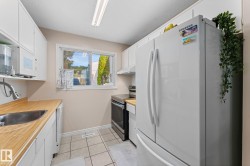 Compact kitchen featuring white cabinetry and wood-finish countertops - 