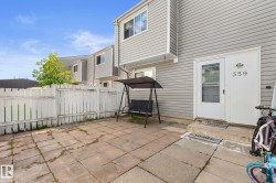 Private patio space featuring square pavers, a white wood fence, and direct exterior access - 