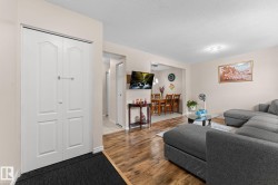 Open-concept living area with wood-finish flooring extending into the dining space - 
