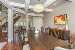 Dining area featuring a coffered ceiling, wood-finish flooring, and a crystal chandelier - 