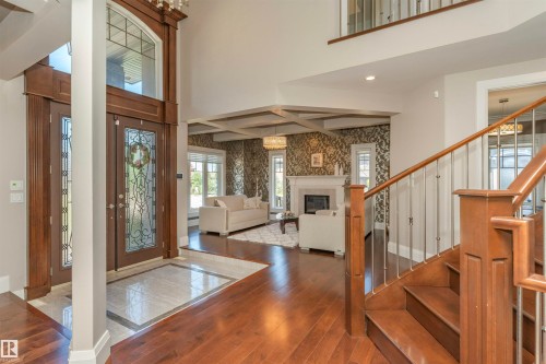 Grand entryway featuring double-height ceilings, wood-finish flooring, and a decorative staircase with metal balusters - 3503 Watson Point(E), Edmonton, AB 