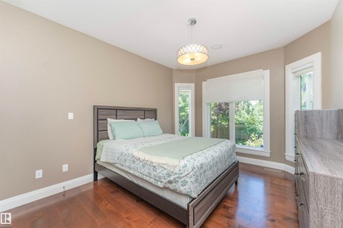 Hardwood flooring throughout featuring a bay window with natural light, neutral wall paint, and a contemporary ceiling fixture - 3503 Watson Point(E), Edmonton, AB 