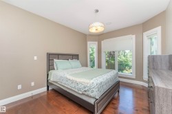 Hardwood flooring throughout featuring a bay window with natural light, neutral wall paint, and a contemporary ceiling fixture - 