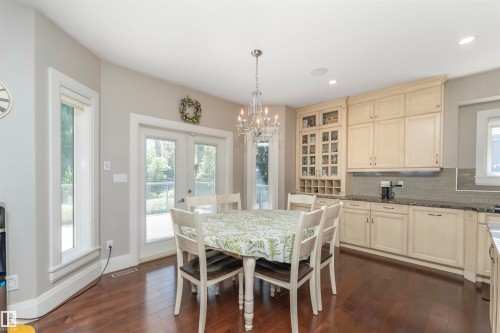 Dining area featuring wood-finish flooring, a crystal chandelier, and French doors - 3503 Watson Point(E), Edmonton, AB 