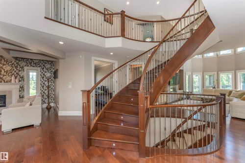 Grand curved hardwood staircase with wrought iron balusters - 3503 Watson Point(E), Edmonton, AB 