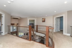 Spacious upper-level landing with plush carpeting and recessed lighting - 