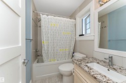 Bathroom featuring a window, vanity with a rectangular undermount sink, granite countertop, and light-tone wood-finish flooring - 