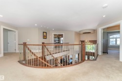 Curved staircase with wood-finish railing and metal balusters - 