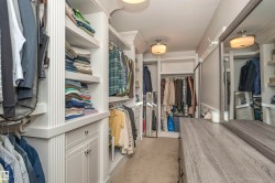 Custom closet system featuring extensive shelving, hanging rods, built-in drawers, and cabinet storage - 